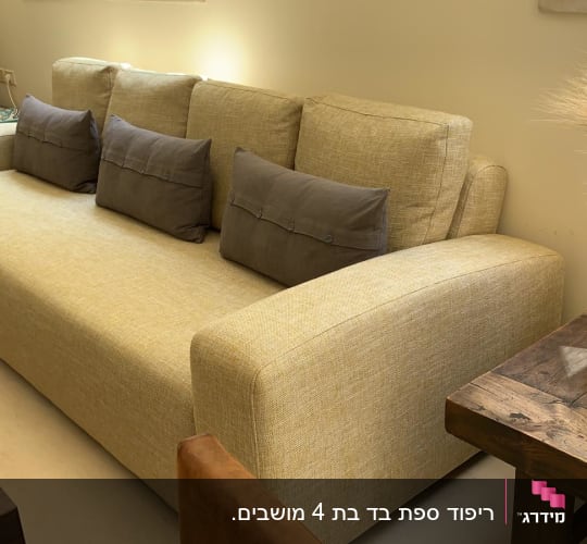 ספה מרופדת עם כריות אפורות על מושביה